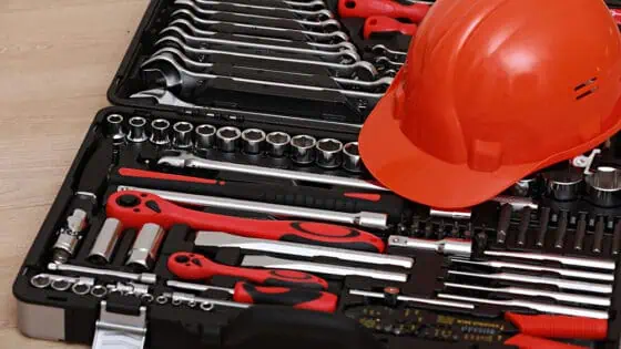 Tools and safety helmet in a technician toolbox for construction or repair work.