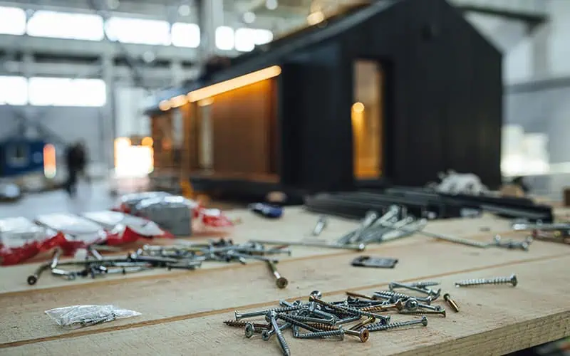 Industrial construction site with tools and hardware scattered on a wooden surface, showcasing the expertise of RMO Agency in project planning and execution.