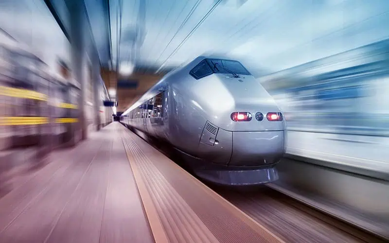 High-speed train arriving at station, modern transportation, fast travel, sleek locomotive, railway transit, transportation technology, urban commuting, high-speed rail in motion, train station platform, efficient travel systems.