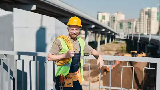 High-resolution construction worker with safety gear on a busy urban job site, highlighting the expertise of RMO Agency in construction and infrastructure projects.