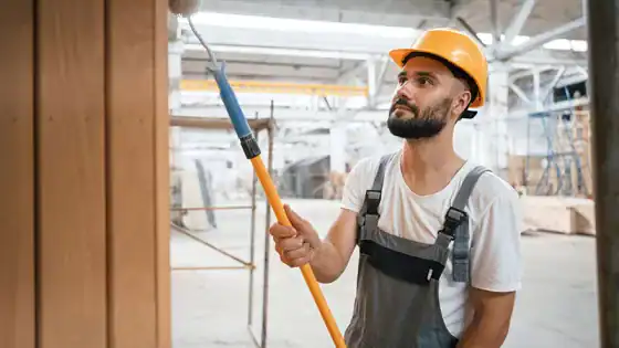 Painted wood wall renovation with construction worker in safety gear.