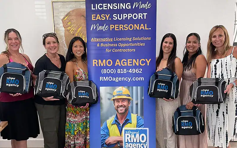 RMO Agency team members holding branded backpacks at a promotional event emphasizing licensing solutions and business opportunities.