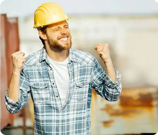 Celebrating achievement in construction with a happy worker wearing safety gear.